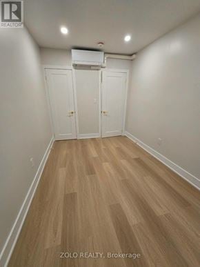 Toronto (Bedford Park-Nortown) apartment for rent - A room with wood flooring and white walls, with a white air conditioner unit on the wall.