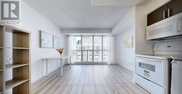 Toronto (Bendale) condo for rent - A well-lit, spacious kitchen area with white appliances and wooden shelving.