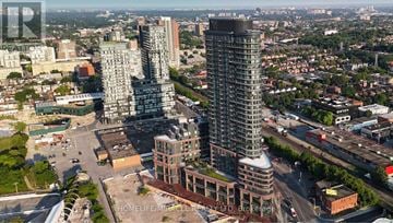 Toronto (Dovercourt-Wallace Emerson-Junction) condo for rent - A cityscape with two prominent buildings in the foreground and a highway in the background.
