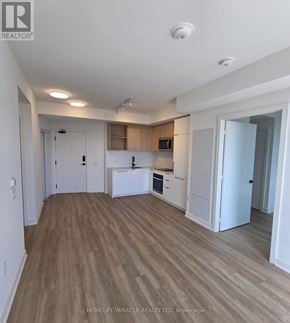 Toronto (Dovercourt-Wallace Emerson-Junction) condo for rent - A well-lit, empty apartment with wooden floors and white walls.