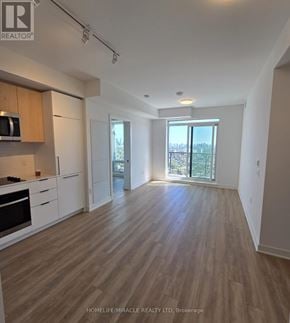 Toronto (Dovercourt-Wallace Emerson-Junction) condo for rent - A spacious kitchen with wooden flooring and white cabinets.