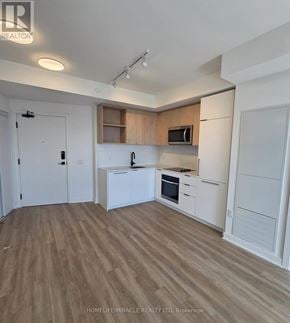 Toronto (Dovercourt-Wallace Emerson-Junction) condo for rent - A kitchen with white cabinets and a wooden floor.