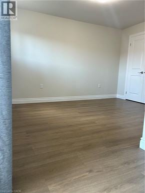 Hamilton apartment for rent - A room with wooden flooring and a white door.