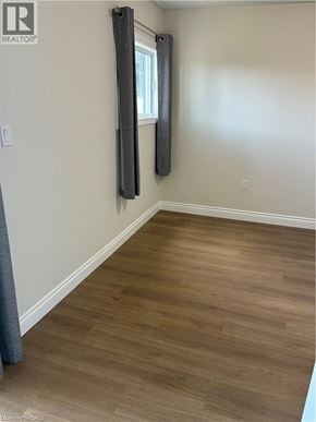 Hamilton apartment for rent - A room with wooden flooring and a window with a grey curtain.