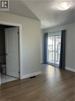 Hamilton apartment for rent - A room with a door and a window with curtains.
