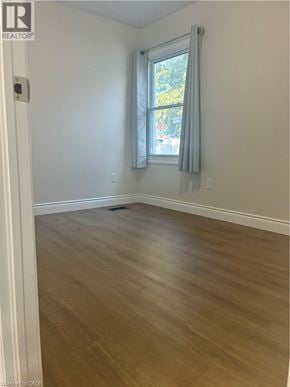 Hamilton apartment for rent - A room with a window and wooden flooring.