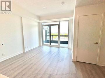 Toronto (Clairlea-Birchmount) condo for rent - A spacious room with a sliding glass door leading to a balcony.