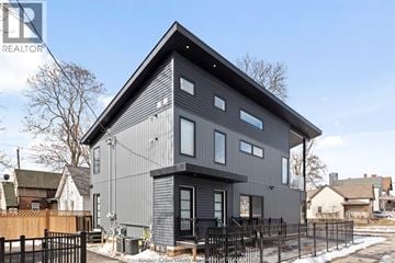 Windsor apartment for rent - A modern house with a grey exterior and a black fence in front.