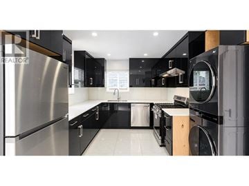 Vancouver apartment for rent - A modern kitchen with black cabinets and stainless steel appliances.