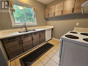 London North (North F) townhouse for rent - A kitchen with a white stove and wooden cabinets.