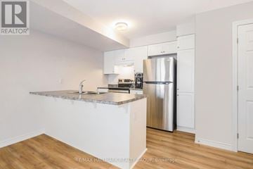Ottawa townhouse for rent - A kitchen with white cabinets and a granite countertop.