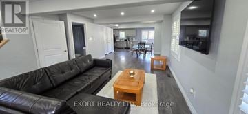 Quinte West (Murray Ward) apartment for rent - A living room with a black leather couch and a wooden coffee table.
