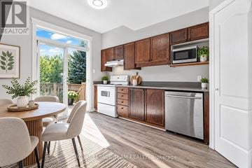 Ottawa townhouse for rent - A kitchen with brown cabinets and a white fridge.
