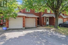 Ottawa townhouse for rent - A house with a white garage door is for sale.