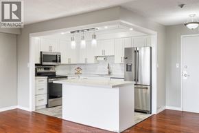 Windsor condo for rent - A modern kitchen with a white island and stainless steel appliances.
