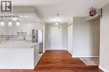Windsor condo for rent - A kitchen with white cabinets and a wooden floor.