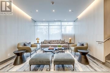 Toronto (Birchcliffe-Cliffside) condo for rent - A modern living room with a grey sofa and a glass coffee table.