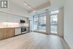Toronto (Birchcliffe-Cliffside) condo for rent - A spacious kitchen with wooden floors and white walls.