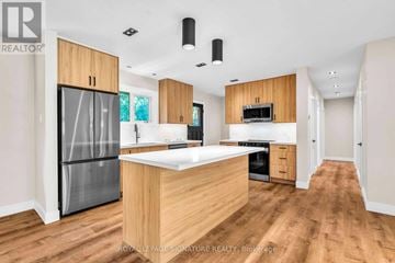 Newmarket (Gorham-College Manor) apartment for rent - A modern kitchen with wooden cabinets and a central island.