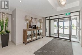 Milton (Wi Willmott) condo for rent - A hallway with a plant, a cabinet with glass doors, and a green exit sign.