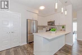 Milton (Wi Willmott) condo for rent - A kitchen with white cabinets and a stainless steel refrigerator.