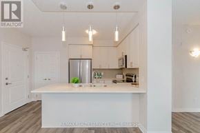 Milton (Wi Willmott) condo for rent - A well-lit kitchen with a white countertop and a refrigerator.