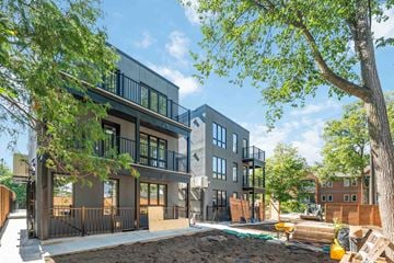 Ottawa apartment for rent - A modern two-story building with a balcony and a tree in front.