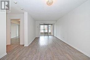 Toronto (Niagara) condo for rent - A spacious room with wooden floors and white walls, with a doorway leading to another room.
