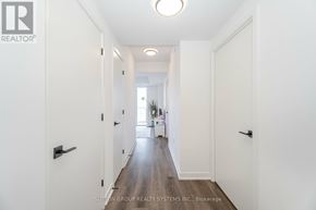 Toronto (Islington-City Centre West) condo for rent - A long hallway with doors on both sides and a plant in the distance.