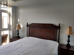 Markham (Unionville) condo for rent - A bedroom with a large bed and two lamps.