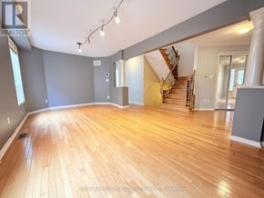 Richmond Hill (Westbrook) apartment for rent - A spacious room with wooden flooring and a staircase.