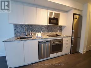 Markham (Unionville) condo for rent - A kitchen with white cabinets and a granite countertop.