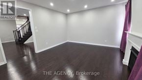 Brampton (Northwest Brampton) apartment for rent - A spacious room with a staircase and wooden flooring.