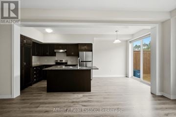 Cambridge townhouse for rent - A spacious kitchen with dark brown cabinets and a large island.