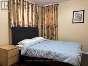 St. Catharines (Ridley) apartment for rent - A bedroom with a bed, nightstand, and curtains.