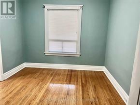 Toronto (South Riverdale) apartment for rent - A room with a wooden floor and a window with blinds.