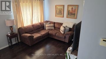 Milton (Co Coates) apartment for rent - A living room with a brown couch and a lamp on a side table.
