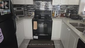 Milton (Co Coates) apartment for rent - A black stove in a kitchen with white cabinets.