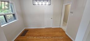 Oakville (Co Central) apartment for rent - A room with a white door and a window with a view of trees and a sign that says "REALTOR".