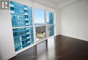 Toronto (Waterfront Communities) condo for rent - A room with a view of a cityscape through large windows.