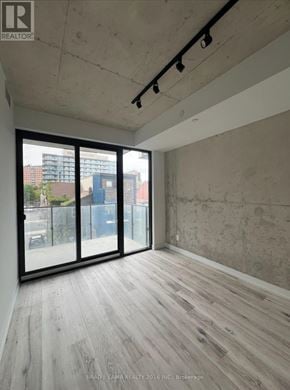 Toronto (Moss Park) condo for rent - A room with a sliding glass door and wooden flooring.
