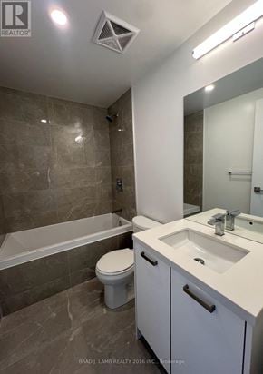 Toronto (Moss Park) condo for rent - A bathroom with a tub, toilet, and sink.