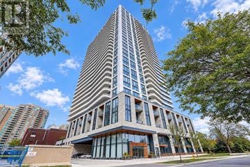 Toronto (Willowdale East) condo for rent - A tall building with a curved facade stands in front of a blue sky.