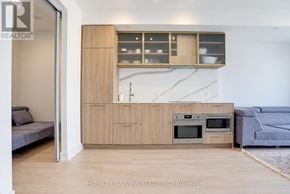 Toronto (Willowdale East) condo for rent - A modern kitchen with wooden cabinets and a marble backsplash.