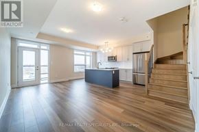 Milton (Cb Cobban) townhouse for rent - A spacious kitchen with a refrigerator, microwave, and stainless steel appliances.