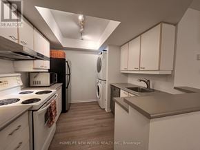 Toronto (Bay Street Corridor) condo for rent - A kitchen with white appliances and wooden cabinets.