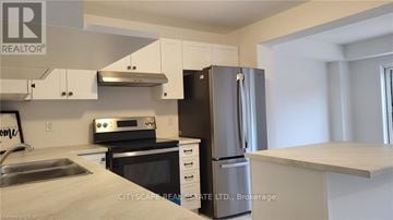 Grey Highlands townhouse for rent - A kitchen with a refrigerator, oven, and sink.
