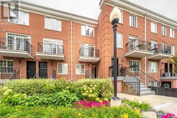 Toronto (Niagara) townhouse for rent - A red brick building with a black gate and a lamp post in front.