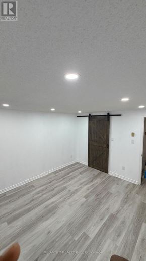 Guelph (Grange Road) apartment for rent - A room with a wooden floor and a white wall.