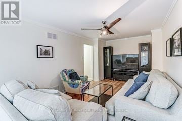 Mississauga (Sheridan) townhouse for rent - A living room with a grey couch, a chair with a blanket, and a coffee table.